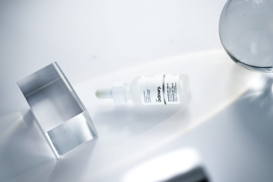 The Ordinary serum bottle lying among acrylic props, seen from above