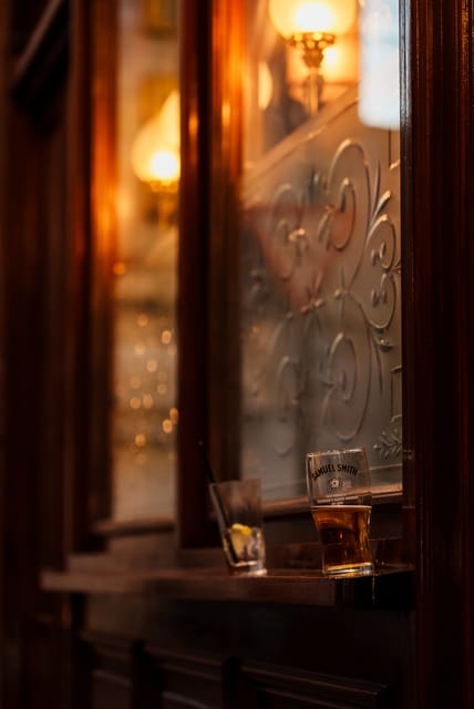 Pint of Samuel Smith beer on a pub window ledge in warm light
